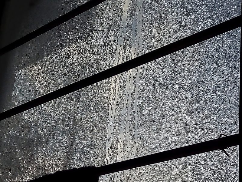 Vidrio de una ventana cubierto de condensación, con gotas formadas sobre la superficie